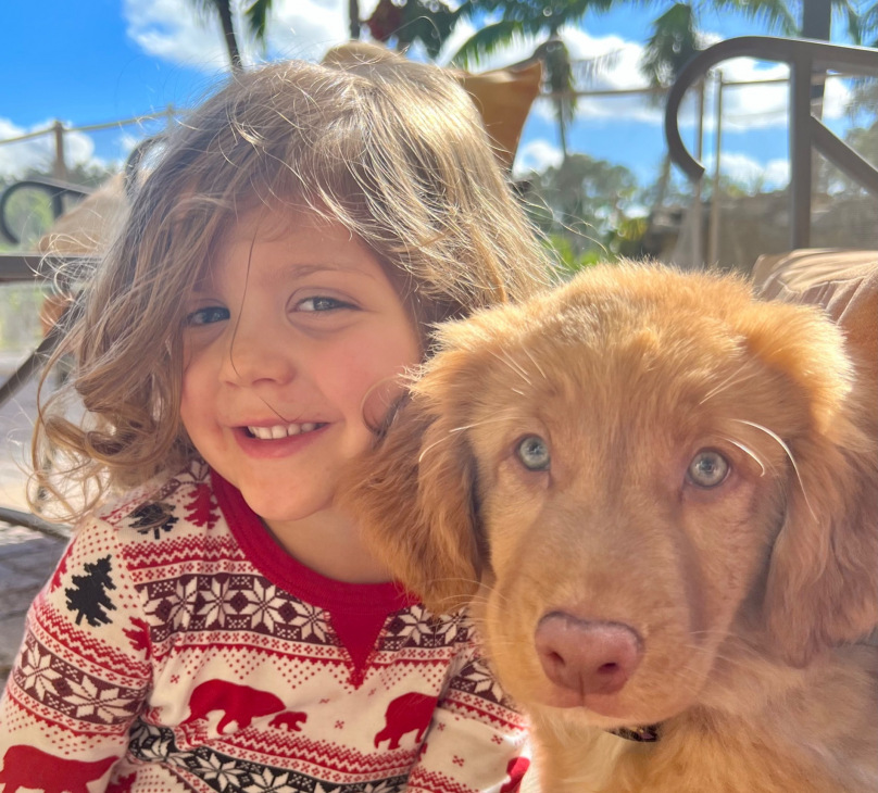 Little girl and Nova Scotia Duck Tolling Retriever